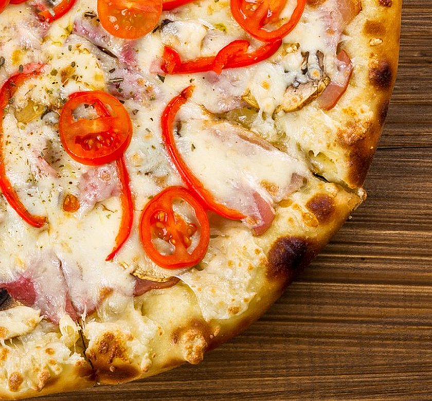 Pizza de jamón y queso con rodajas de tomate